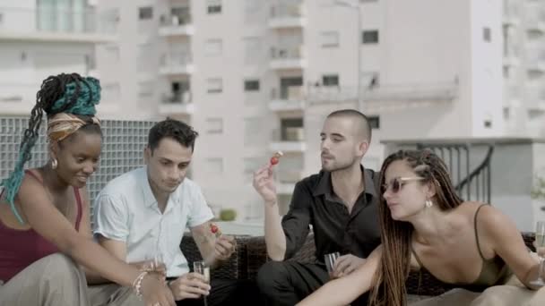 Slow motion of cheerful coworkers eating canapes in rooftop cafe — Vídeo de Stock