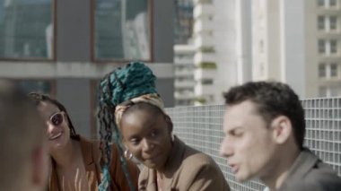 Mutlu iş ortaklarının açık havada birlikte güldüğü orta boy bir fotoğraf.