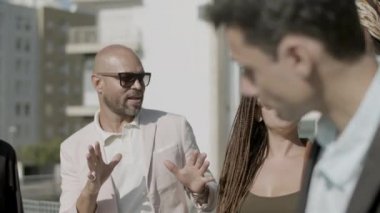 Çatıda durup konuşan mutlu çalışanların yavaş çekimleri.