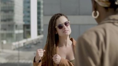 Mutlu bir kadının iş ortağıyla dışarıda konuşması ön planda.