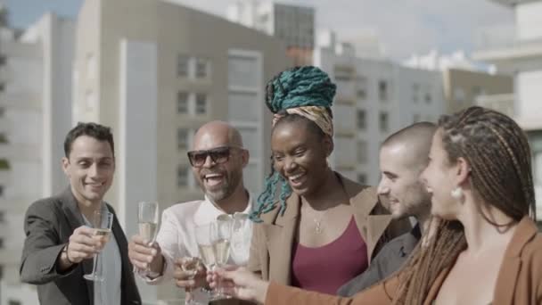 Tiro de mano de felices compañeros de trabajo brindando con vino espumoso — Vídeo de stock