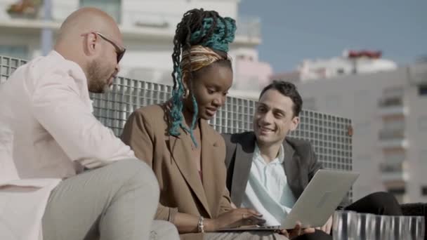 Side view of diverse business partners looking at laptop screen — Vídeo de Stock