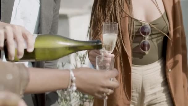 Medium shot of man pouring sparkling wine into glasses at party — Vídeo de Stock