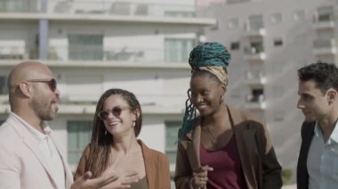 Mutlu çalışanlar yaz günü çatı partisinde konuşuyorlar.