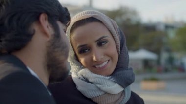 Açık havada sevgili arayan tesettürlü hoş bir kadın.