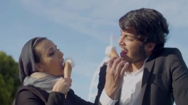 Neşeli Arap çift dışarıda dondurma yiyor ve konuşuyor.