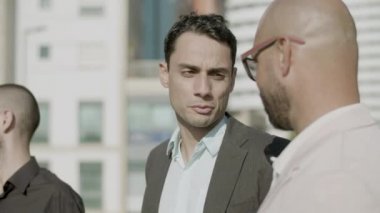 Tasasız iş adamlarının açık havada konuştuğu yakın plan çekimler.