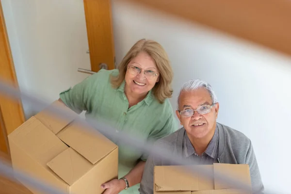 Glada äldre par flyttar in i nytt hus Stockfoto