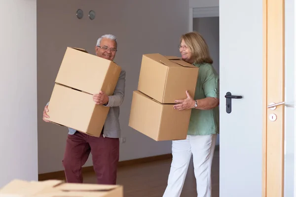 Smiling elderly couple moving into new house