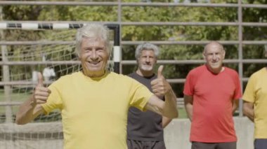 Spor stadyumunda duran mutlu son sınıf futbolcusu.