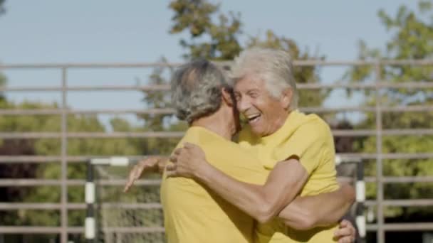 Szczęśliwi starsi sportowcy przytulają się i uśmiechają po zdobyciu gola — Wideo stockowe