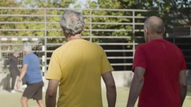 Mutlu üst düzey futbolcular daire çizip zıplıyorlar.