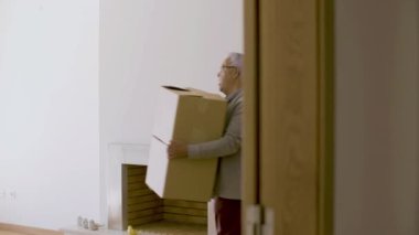 Olgun bir eş ve koca karton kutularla yeni eve giriyor.