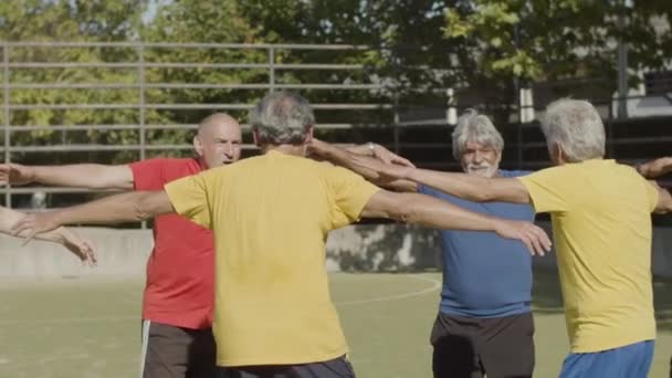 Weseli starsi piłkarze skaczący w kółko na zewnątrz — Wideo stockowe