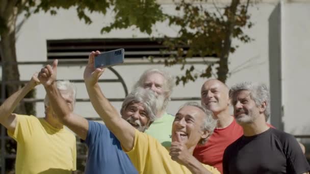 Zespół szczęśliwych starszych piłkarzy robi selfie na zewnątrz — Wideo stockowe
