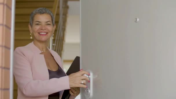 Cheerful real estate agent opening door of house — Stock Video