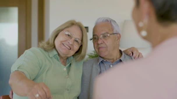 Šťastná starší žena ukazuje klíče k novému domu doma — Stock video