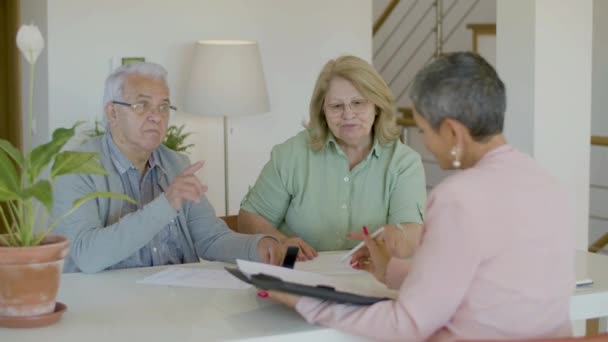 Casal sênior conversando com corretor de imóveis enquanto sentado à mesa — Vídeo de Stock