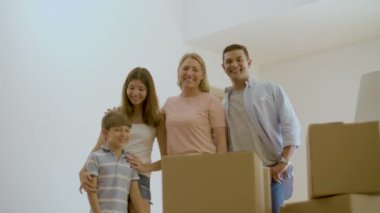 Mutlu bir aile yeni evinde kameraya gülümsüyor.