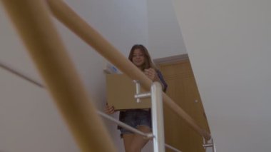 Yeni eve karton kutular taşıyan tatlı bir anne ve kız.