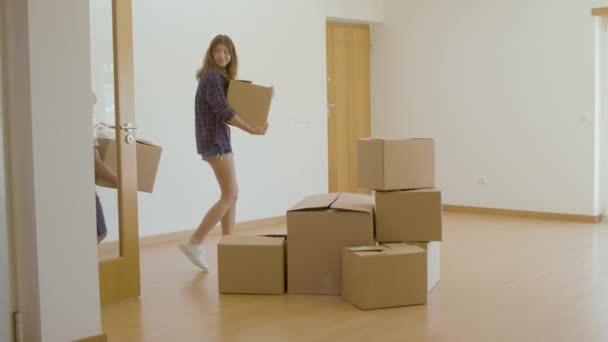 Podekscytowana rodzina wchodząca do nowego domu z kartonowymi pudełkami — Wideo stockowe