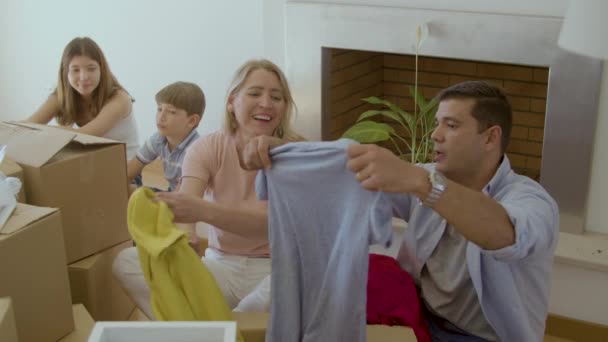 Ευτυχισμένο ζευγάρι τακτοποιεί τα ρούχα μετά τη μετακόμιση στο νέο σπίτι — Αρχείο Βίντεο