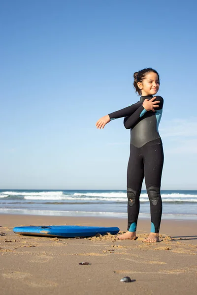 Smiling little girl exercising on beach — Stock Photo, Image