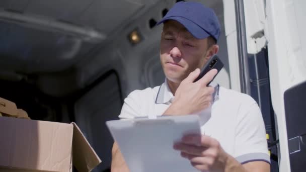 有重点的快递员用面包车呼叫客户并在平板电脑上书写 — 图库视频影像