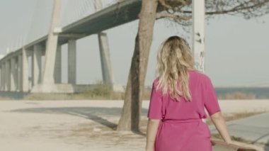 Elbiseli güzel kız kaykay parkına gidiyor.
