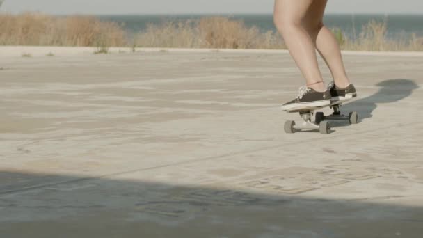 Unerkennbares Mädchen reitet an Sommertagen im Freien Longboard — Stockvideo