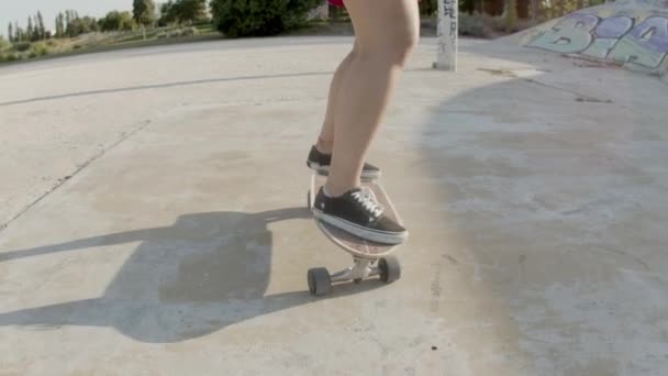 Nierozpoznawalna dziewczyna balansująca na longboardzie w skate parku — Wideo stockowe