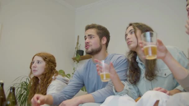 Amigos Viendo Televisión Bebiendo Cerveza Apoyando Equipo Casa Media Toma — Vídeo de stock