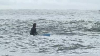 Okyanusta engelli sörfüne odaklanmış sporcu.