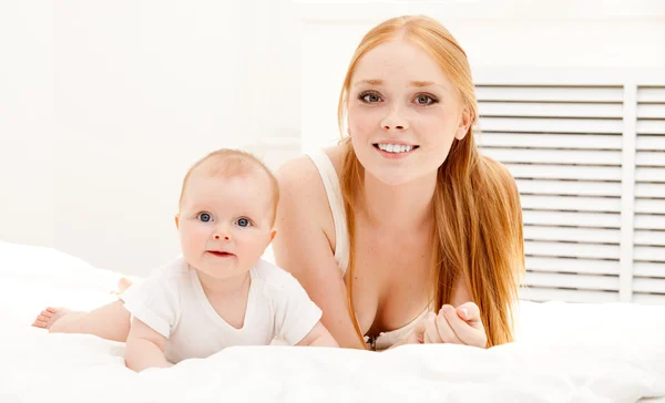 Mother lies on carpet with baby — Stock Photo, Image