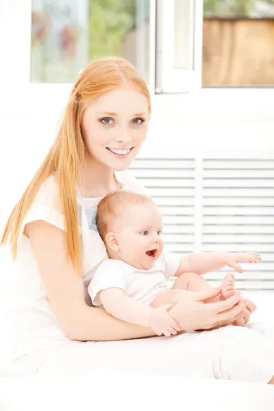 Mamma och baby sitter, leende — Stockfoto