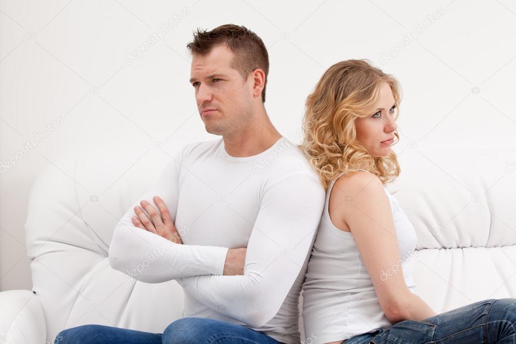 Young sad couple sitting