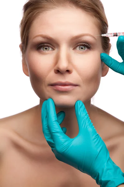 Mooie vrouw krijgt een injectie in haar gezicht — Stockfoto