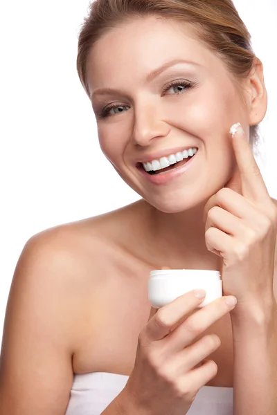 Woman applying cosmetic cream on a clean fresh face Stock Picture