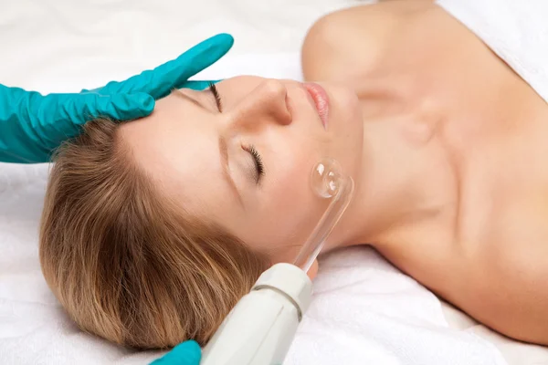 Young woman and medical device touching her face — Stock Photo, Image