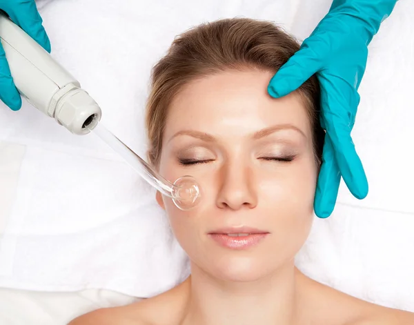 Young woman and medical device touching her face — Stock Photo, Image