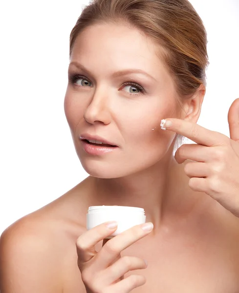 Mujer aplicando crema cosmética en una cara limpia y fresca —  Fotos de Stock