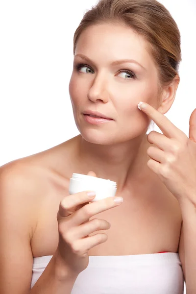 Mujer aplicando crema cosmética en una cara limpia y fresca — Foto de Stock