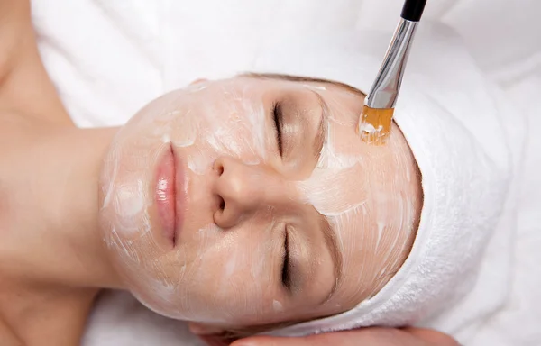 Terapia de spa para mulher recebendo máscara facial no salão de beleza — Fotografia de Stock