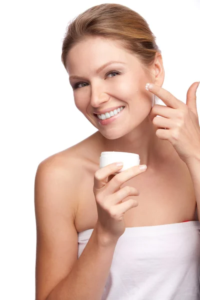 Donna che applica crema cosmetica su un viso fresco e pulito — Foto Stock