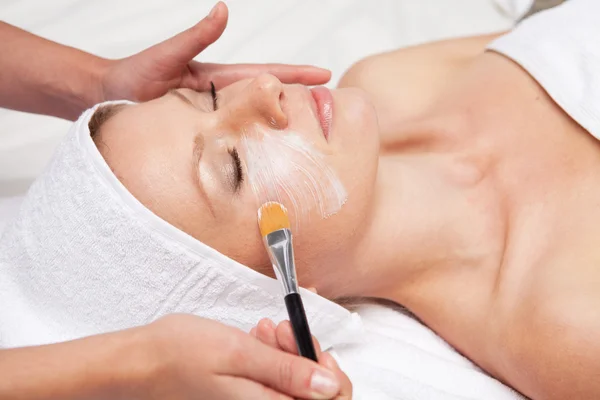Thérapie spa pour femme recevant un masque facial au salon de beauté — Photo