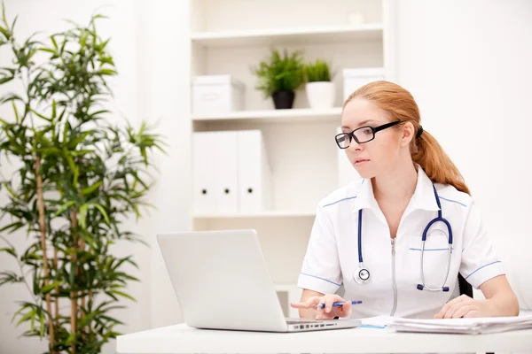 Portrait of a smiling physician working in her office — Stock Photo, Image