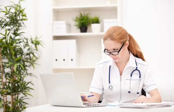 Portrait of a smiling physician working in her office — Stock Photo, Image