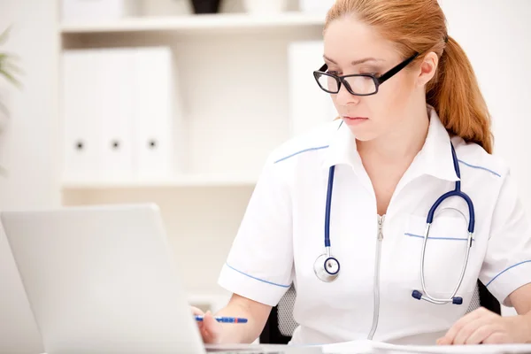 Portrait of a smiling physician working in her office — Stock Photo, Image