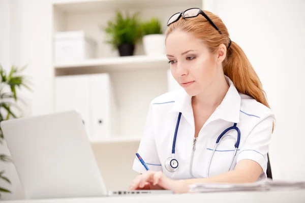 Portrait of a smiling physician working in her office — Stock Photo, Image