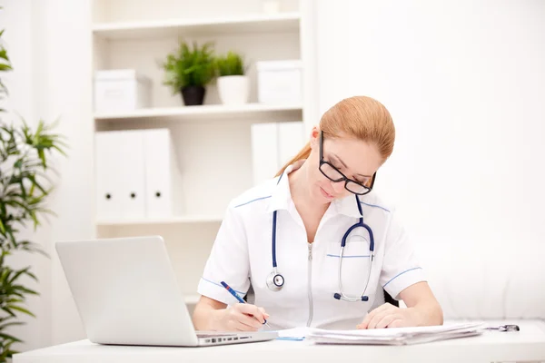 Portrait of a smiling physician working in her office Stock Picture